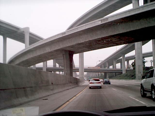 traveling through the 
bottom level of the 110-105 interchange, concrete ramps swooping above in 
several directions.