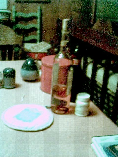 still 
life with wine bottle and potholder on pink tablecloth