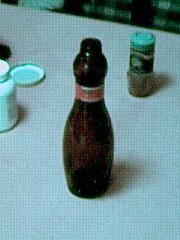 a brown 
bottle in shape of bowling pin, with label round the neck.